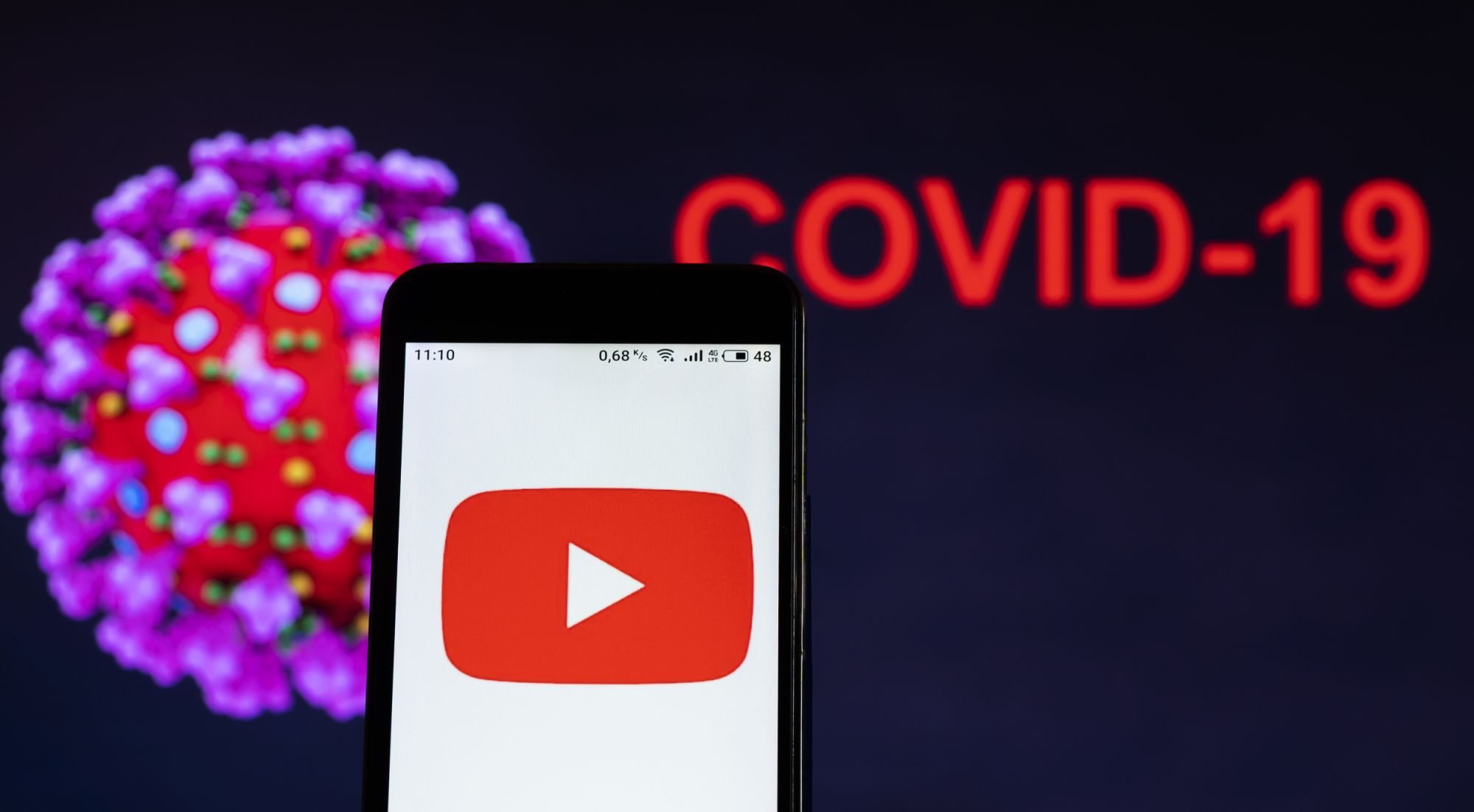 UKRAINE - 2020/12/18: In this photo illustration, a Youtube logo seen displayed on a smartphone with a computer model of the COVID-19 coronavirus in the background. (Photo Illustration by Igor Golovniov/SOPA Images/LightRocket via Getty Images)