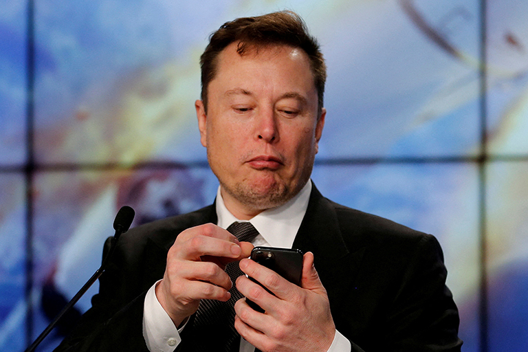FILE PHOTO: Elon Musk looks at his mobile phone in Cape Canaveral, Florida, U.S. January 19, 2020.